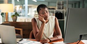 Business, trading and black woman with computer, fatigue and exhausted with deadline for audit. African person, pc and investor in office, overwhelmed and tired with burnout, email and brain fog.
