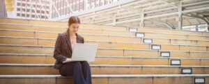 Business woman using laptop sits on the steps. Business people concept.
