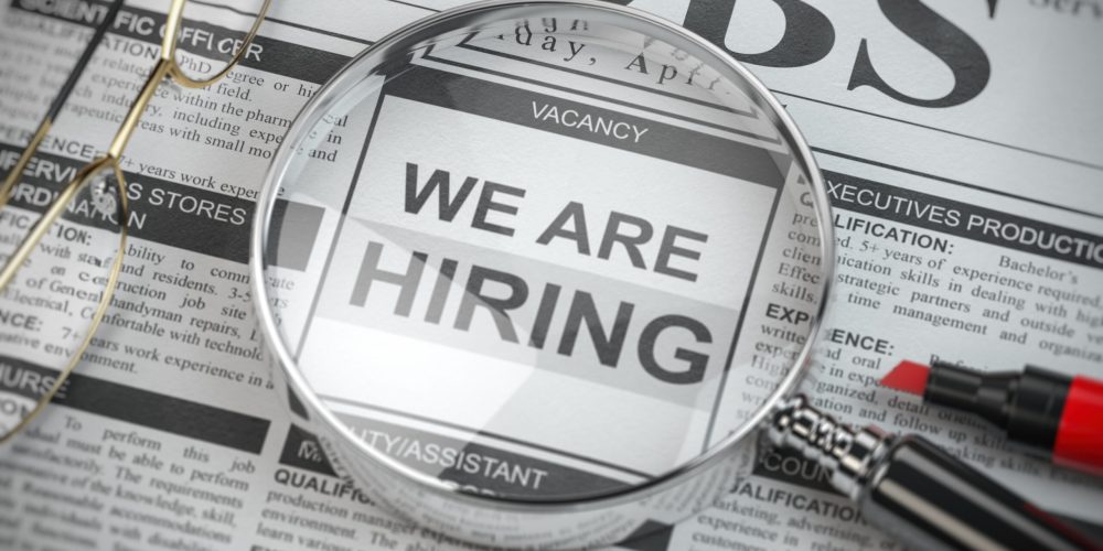 We are hiring. Job search and employment concept. Magnified glass with jobs classified ads in newspaper, 3d illustration