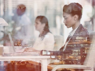Focused businesswoman with colleague working on laptop in office